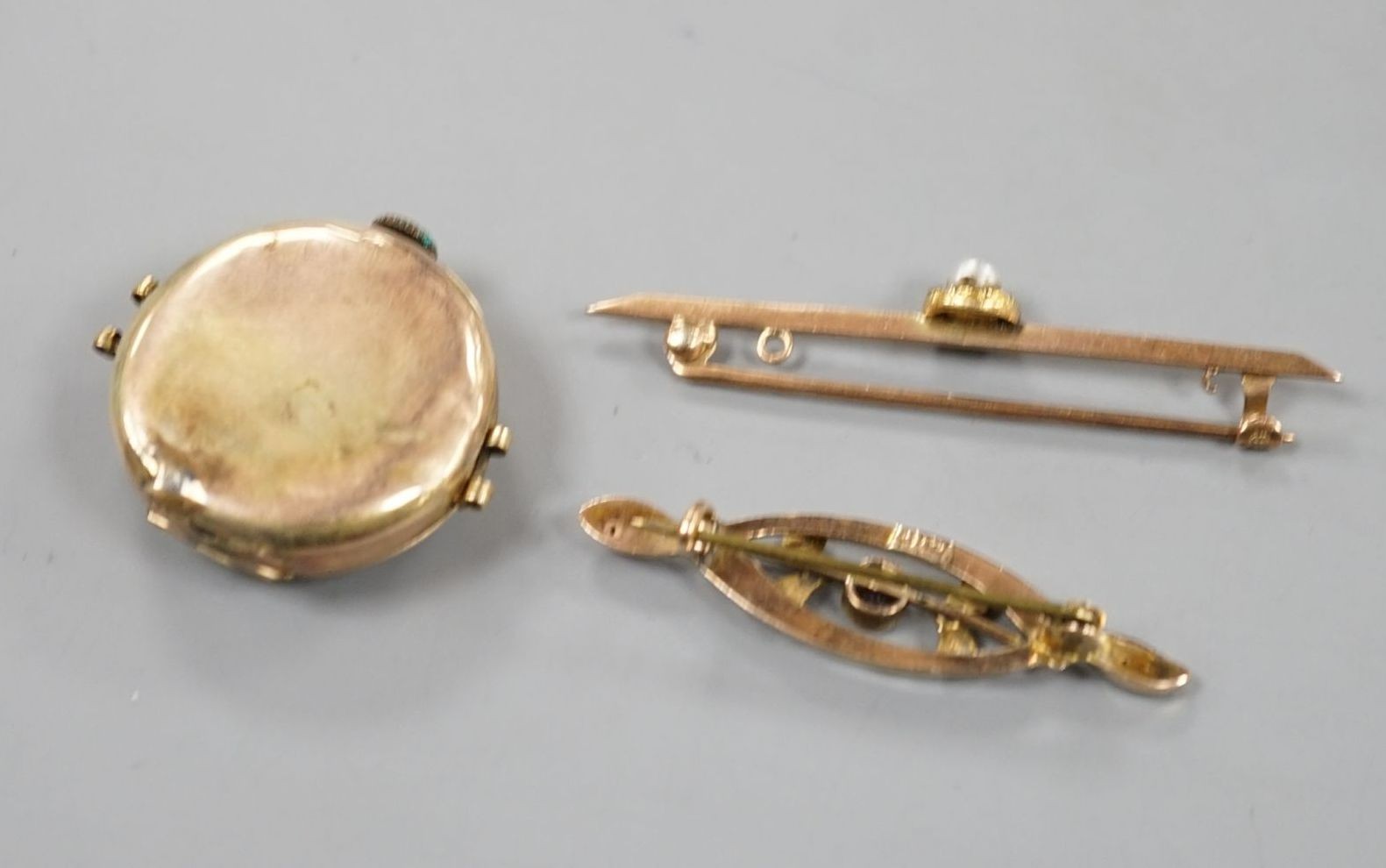 Two early 20th century 9ct and gem set bar brooches and a lady's 9ct manual wind wrist watch, no strap